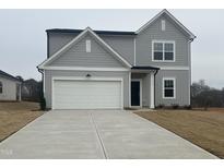 Charming two-story home featuring gray siding, a two-car garage, and a well-manicured front yard at 11816 Salers Loop, Middlesex, NC 27557