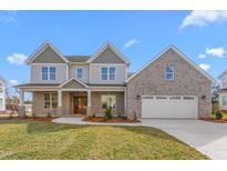 Beautiful two-story home with brick accents, a well-manicured lawn, and a two-car attached garage at 1246 Jamestowne Dr, Elon, NC 27244