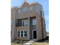 New construction townhouse with brick and siding, balcony, and manicured landscaping at 201 Broomgrove Way, Wake Forest, NC 27587