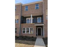 Modern brick townhome with covered entry and balcony, offering stylish urban living at 205 Broomgrove Way, Wake Forest, NC 27587