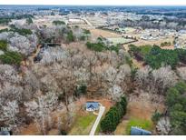 Aerial view of a house on a wooded lot, showcasing its location and surrounding area at 210 Charlotte Ct, Clayton, NC 27520