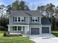 Two-story house with gray siding, two-car garage, and a stone facade at 309 Starry Sky Dr, Benson, NC 27504