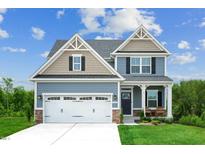 Two-story house with gray siding, white garage door, and landscaping at 600 Mohinda Way, Willow Springs, NC 27592