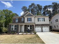 Two-story home featuring a stone and siding exterior with a two-car garage and manicured front lawn at 752 Portland Rose Dr, Knightdale, NC 27545
