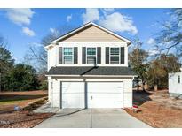 Two-story house with a white garage door and beige siding at 810 Brake St, Nashville, NC 27856