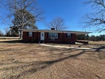 Brick ranch house with covered porch and large yard at 1002 Godwin Ln, Dunn, NC 28334