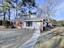 Brick ranch home with landscaped yard and walkway at 1100 Somerset Rd, Raleigh, NC 27610