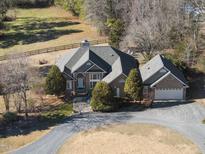Brick home with detached garage, situated on a large lot with a long driveway at 265 Verde Rd, Apex, NC 27523
