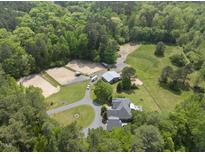 Expansive estate featuring stables, riding area, and a well-maintained home amidst lush greenery at 265 Verde Rd, Apex, NC 27523