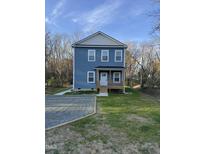 Charming two-story home featuring light blue siding, a covered front porch, and a well-maintained lawn at 343 Foster St, Burlington, NC 27217