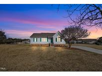 Brick ranch home with green shutters, landscaping, and a spacious yard at 3901 La Varra Dr, Clayton, NC 27520