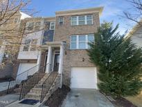 Brick front exterior of charming townhome with attached garage at 5023 Lalex Ln, Cary, NC 27519