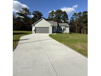 Newly built home with gray siding, two-car garage, and a long driveway at 60 Holly Grove Ln, Lillington, NC 27546