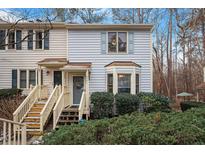 Two-story townhome with light gray siding, wooden stairs, and landscaping at 6539 English Oaks Dr, Raleigh, NC 27615