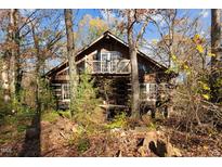 Rustic log cabin nestled in woods, features balcony and large windows at 90 Little Indian Creek Rd, Goldston, NC 27252