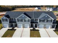 Three-unit townhome building with gray siding and two-car garages at 285 Moyer Dr # 119, Graham, NC 27253