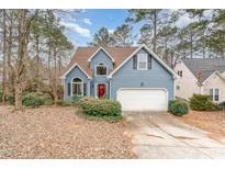 Two-story house with blue siding, white garage door, and landscaping at 316 Trafalgar Ln, Cary, NC 27513