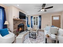 Cozy living room with a stone fireplace, ceiling fan, and lots of natural light at 402 W Clay St, Mebane, NC 27302