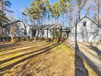 Gray house with a three-car garage and spacious lawn at 6012 Wildorlyn Cir, Raleigh, NC 27603