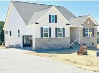 Charming two-story home boasts brick accents, an attached garage, and newly paved driveway at 93 Ausban Ridge Ln # 033, Four Oaks, NC 27524