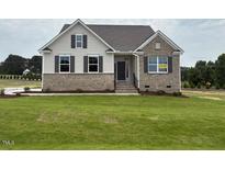 Charming home featuring brick and vinyl siding, inviting entryway, and a well-manicured lawn at 93 Ausban Ridge Ln # 033, Four Oaks, NC 27524