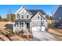 Charming two-story home featuring a well-manicured lawn, covered porch, and attached two-car garage at 102 Belmont Stakes Ln, Wendell, NC 27591