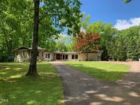 Ranch home with stone accents, large yard, and long driveway at 1126 Trailwood Dr, Raleigh, NC 27606