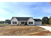 Charming single-story home with a white exterior, black shutters, and a two-car garage at 233 N Movado Trl, Kenly, NC 27542