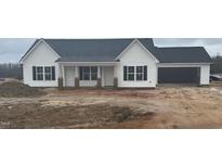 New construction, single-story home featuring white siding, a dark roof, and an attached garage at 233 N Movado Trl, Kenly, NC 27542
