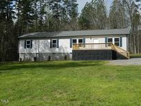Charming single-story home featuring a lovely front porch and well-maintained lawn and blue shutters at 3050 Bennett Siler City Rd, Bennett, NC 27208