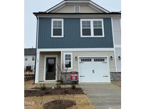 Two-story home with neutral siding, white garage door, and landscaping at 40 Shay St, Angier, NC 27501
