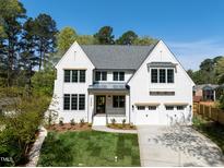 Stunning two-story home with a manicured lawn, attached garage, and classic white painted brick at 4005 Brevard Pl, Raleigh, NC 27609