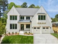 Striking white brick home with a manicured lawn and two-car garage at 4005 Brevard Pl, Raleigh, NC 27609
