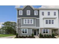 Two-story townhome with gray and white siding, and landscaping at 703 Lucky Clover Way, Fuquay Varina, NC 27526