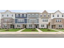 New townhome community featuring three-story townhouses with modern brick and siding at 705 Lucky Clover Way, Fuquay Varina, NC 27526