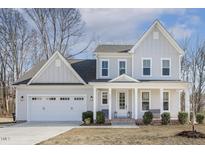 Charming two-story home featuring a covered porch with white columns and an attached two-car garage at 221 Old Hickory Dr, Raleigh, NC 27603