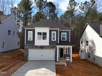 Charming new two-story home with white garage and stone accents near a wooded area at 3275 Roundly Rd # 10, New Hill, NC 27562