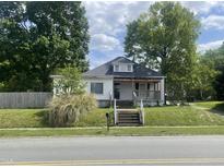 Charming single-story home with a classic front porch and a cozy, welcoming feel on a partially cloudy day at 614 Tucker St, Burlington, NC 27215