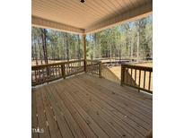 An expansive wooden deck provides an inviting outdoor space with a scenic view of the surrounding woodlands at 65 Watermelon Dr, Franklinton, NC 27525