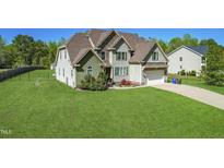 Lovely two-story home featuring stone accents, a manicured lawn, and an attached two-car garage at 7945 Parker Mill Trail, Fuquay Varina, NC 27526
