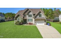 Charming two-story home with a well-manicured lawn, two-car garage, and attractive landscaping at 7945 Parker Mill Trail, Fuquay Varina, NC 27526