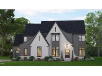 Two-story home with gray and white brick exterior, large windows and landscaped lawn at 109 Evander Way, Pittsboro, NC 27312