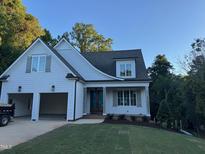 Charming home featuring white siding, a two-car garage, a landscaped front yard and welcoming entryway at 129 Windel Dr, Raleigh, NC 27609