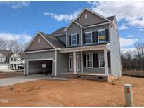 Two-story home boasts gray siding, a covered porch, and an attached two-car garage at 19 Grassland Dr, Garner, NC 27529