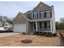 Charming two-story home with a two-car garage, front porch, and landscaped yard at 19 Grassland Dr, Garner, NC 27529
