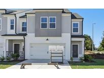 Two-story townhome with gray and white siding, two-car garage, and landscaping at 2000 Regal Dr # 88, Durham, NC 27703