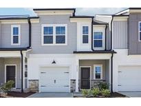 Modern two-story townhome with gray siding, white trim, and a two-car garage at 2006 Regal Dr # 85, Durham, NC 27703