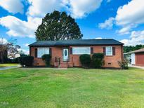 Brick ranch house with a spacious lawn and mature trees at 2923 Mckinney St, Burlington, NC 27217