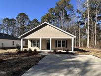 Newly constructed home with a covered porch and landscaped yard at 303 E Pope Ave, Kenly, NC 27542