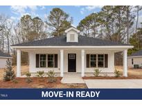 Charming single-story home with a black front door, white trim, and a well-manicured lawn at 305 E Pope Ave, Kenly, NC 27542